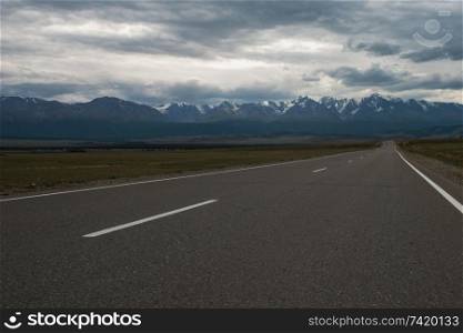Empty route in Altai mountains on snowly peaks of North-Chui ridge of Altai mountains. Altai mountains road