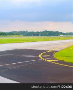 Empty runway at Changi airport in Singapore, departuring plane in the background