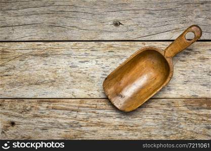 empty rustic wooden scoop against weathered barn wood