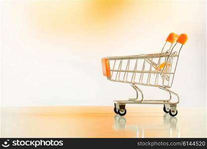 Empty shopping cart on a floor in orange environment