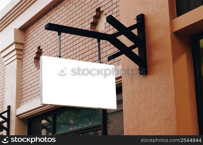 Empty signage and blank mock up hanging on street with copy space