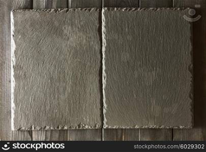 Empty slate plates over black wooden background