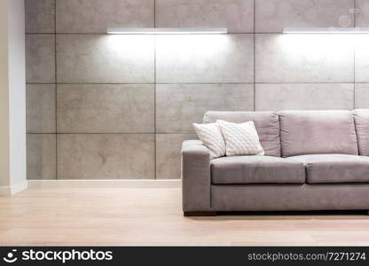 Empty sofa against illuminated wall in apartment