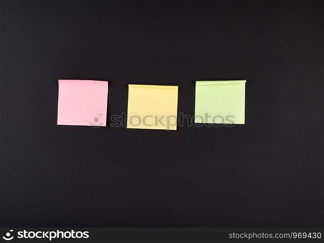 empty square multi-colored stickers hang on a black board in a wooden frame, business concept