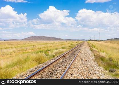 Empty steel railway track in countryside rural farmland area of South Africa