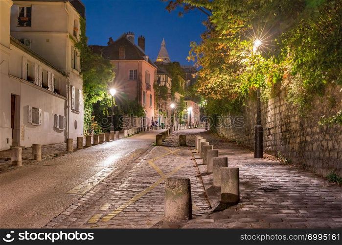 Empty street and the Sacre-Coeur at night, quarter Montmartre in Paris, France. Montmartre in Paris, France