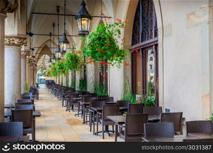 empty street cafe, located in the arch of shopping arcades in th. empty street cafe, located in the arch of shopping arcades in the center of Krakow in the square in the morning