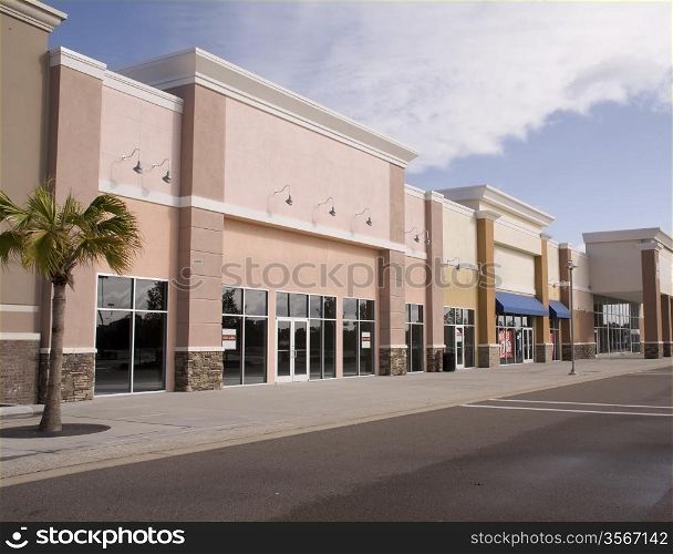 empty strip mall with pastel stucco and stone accents