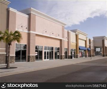 empty strip mall with pastel stucco and stone accents