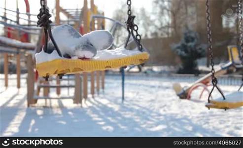 empty swings on the playground in winter