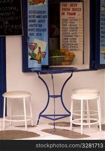 Empty table and stools in Mykonos Greece
