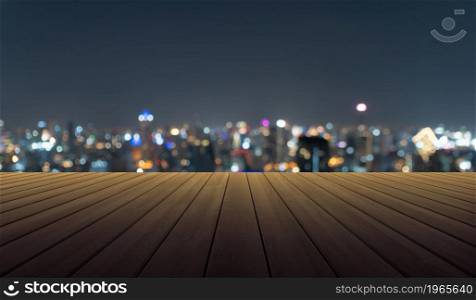 Empty table board with bokeh abstract background of skyscraper buildings in Bangkok city, Thailand with lights, Blurry photo at night time. Cityscape.