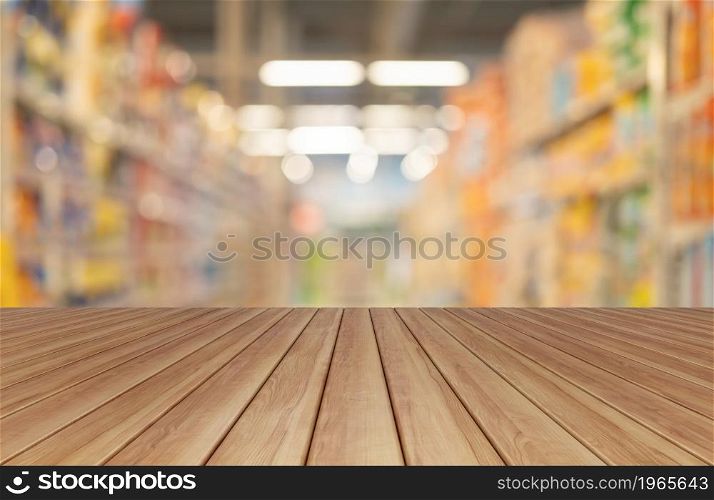 Empty table board with bokeh blurry background of aisle of label products on shelves at supermarket or grocery store. Food shopping. Lifestyle. Abstract