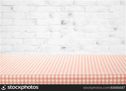 Empty table cover with pink and white tablecloth over white brick wall background, banner, table top, counter design for food and product display montage