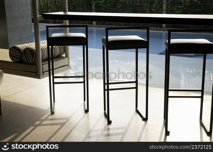 Empty table top and blurred swimming pool in tropical resort, stock photo