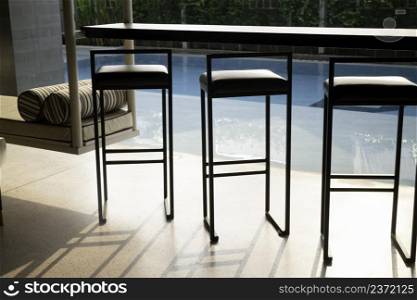 Empty table top and blurred swimming pool in tropical resort, stock photo