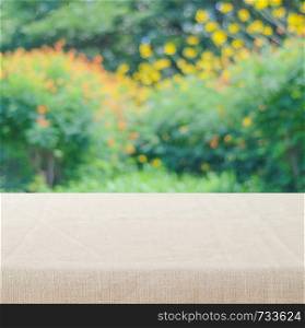 Empty table with linen tablecloth over vintage cement wall background, product display montage