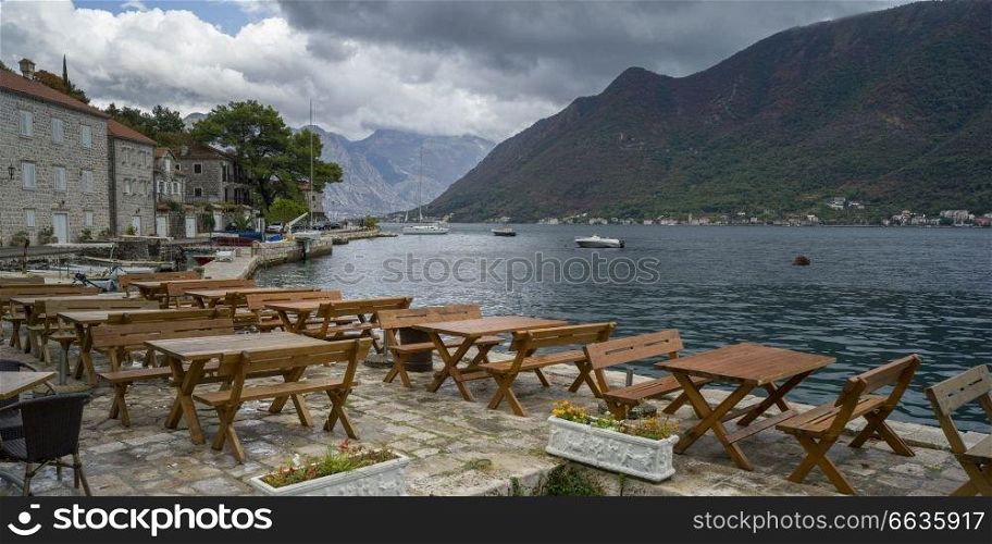 Empty tables and chairs at waterfront restaurant, Perast, Bay of Kotor, Montenegro
