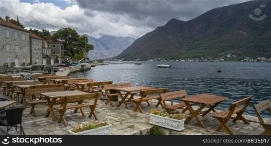 Empty tables and chairs at waterfront restaurant, Perast, Bay of Kotor, Montenegro