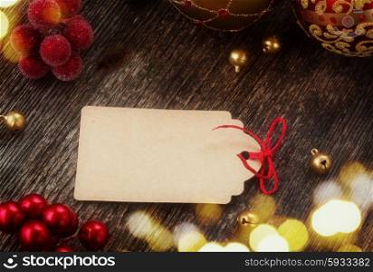 empty tag with red bow in frame of christmas decorations, retro toned