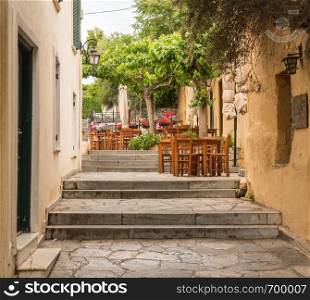 Empty Taverna on steps in ancient neighborhood of Plaka in Athens by the Acropolis. Taverna in ancient residential district of Plaka in Athens Greece
