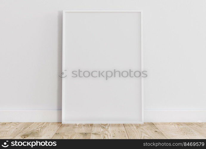 Empty thin white frame on light wooden floor with white wall behind it. Empty poster frame mockup. Empty picture frame mockup. Blank photo frame.