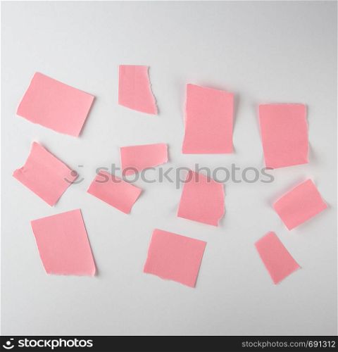 empty torn pieces of pink paper on a white background, top view