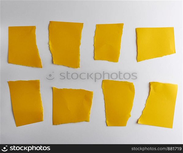 empty torn pieces of yellow paper on a white background, close up