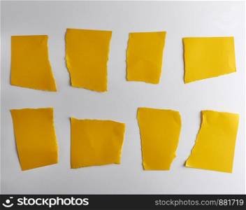 empty torn pieces of yellow paper on a white background, close up