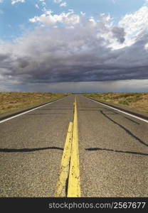 Empty two lane highway leading to desert horizon.