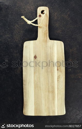 Empty vintage cutting board on dark background - food background concept