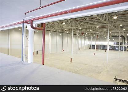 Empty warehouse with red piping