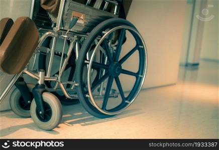 Empty wheelchair near hallway in hospital for service patient and people with disability. Medical equipment in hospital for assistance old people. Chair with wheels for patient care in nursing home.