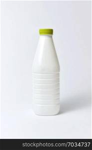 Empty white bottle for dairy products with green cover from plastic, mock-up on a light gray background, copy space.. White plastic bottle for milk, mock up on a light background.