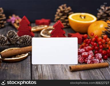 empty white business card on a gray wooden background in the middle of a Christmas decor