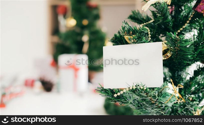 Empty white card on Christmas tree. Holiday copyspace concept.