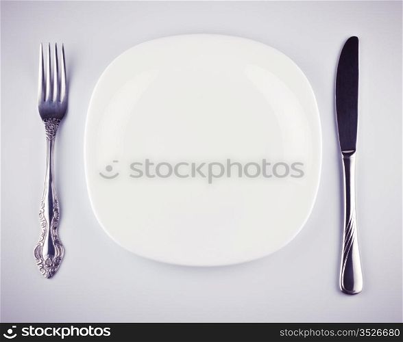 empty white dish knife and fork on grey background