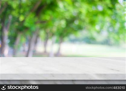 Empty white marble table over blur green nature park background, product display montage