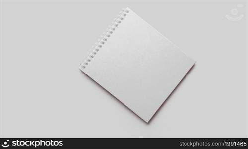 Empty white notebook mockup with soft shadows on neutral grey concrete background.