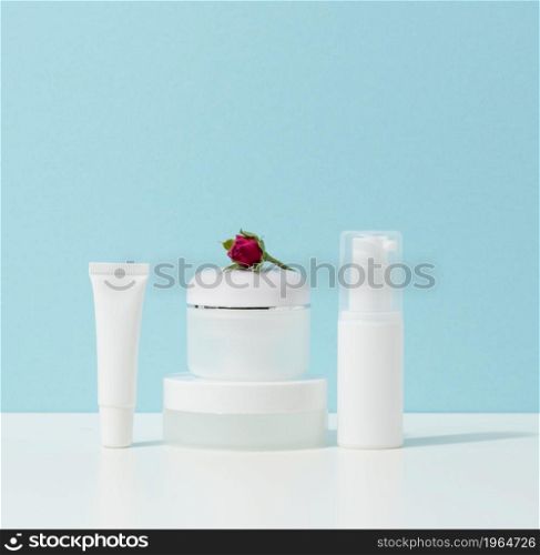 empty white plastic tubes and jars for cosmetics. Packaging for cream, gel, serum, advertising and product promotion, mock up