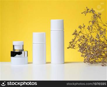 empty white plastic tubes and jars for cosmetics. Packaging for cream, gel, serum, advertising and product promotion, mock up