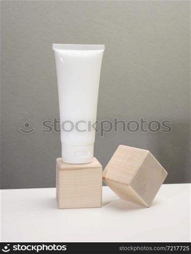 empty white plastic tubes for cosmetics on a white table. Packaging for cream, gel, serum, advertising and product promotion, mock up
