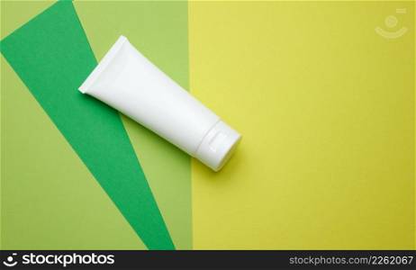 empty white plastic tubes for cosmetics. Packaging for cream, gel, serum, advertising and product promotion, green background