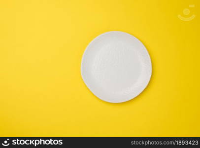 empty white plate on white yellow background, top view
