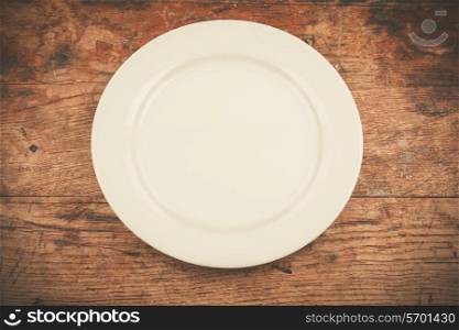 Empty white plate on wood table
