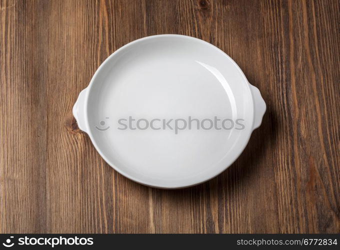 Empty white plate on wooden table