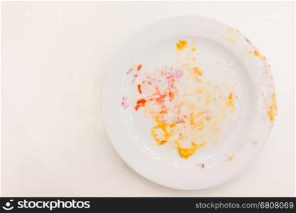 Empty white plate with crumbs and cream after eating
