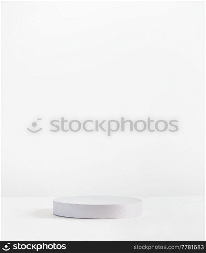 Empty white podium on white wall background for product placement. Modern product display. Copy space on showcase platform for marketing and presenting. Front view.