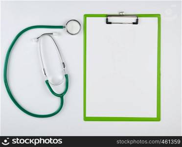 empty white sheets and medical stethoscope on a white background, place for writing the patient's prescription