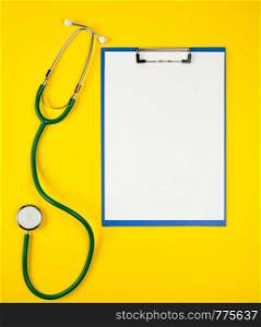empty white sheets and medical stethoscope on a yellow background, copy space
